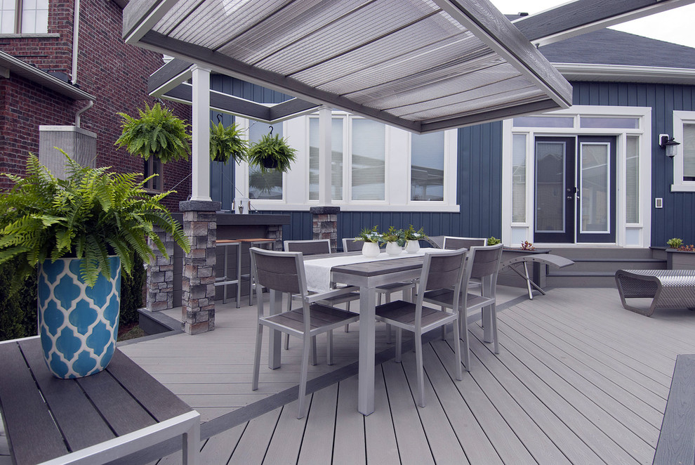 Mid-sized industrial backyard deck in Toronto with a fire feature and a pergola.