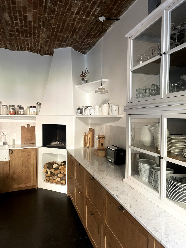 Idéer för stora lantliga vitt kök, med en nedsänkt diskho, skåp i ljust trä, marmorbänkskiva, vitt stänkskydd, stänkskydd i keramik, vita vitvaror och svart golv