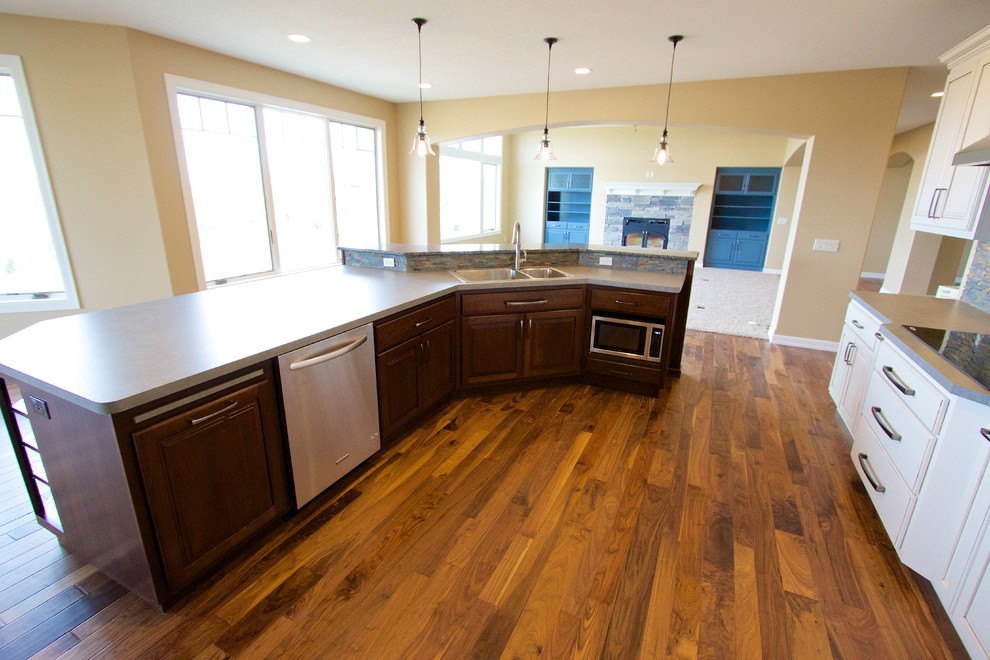 Inspiration for a huge open concept kitchen remodel with raised-panel cabinets, dark wood cabinets, solid surface countertops and an island