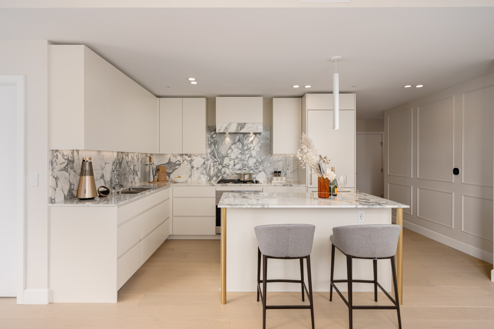 Inspiration for a contemporary l-shaped medium tone wood floor and brown floor kitchen remodel with flat-panel cabinets, white cabinets, an island, gray countertops, a double-bowl sink, gray backsplash, stone slab backsplash and stainless steel appliances