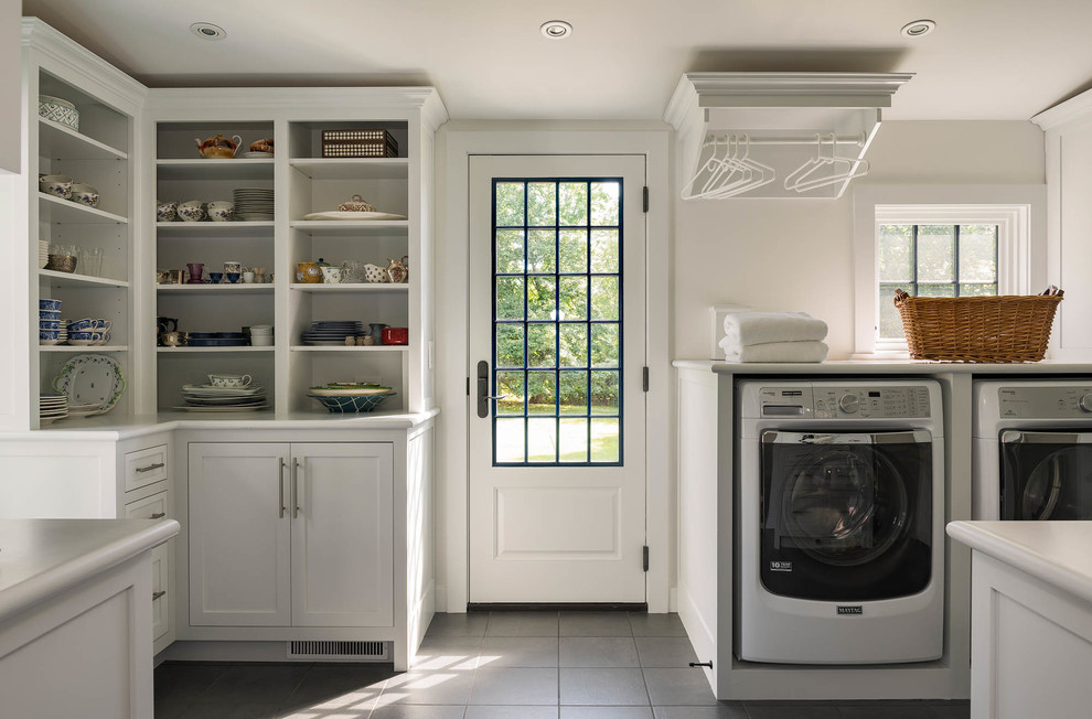This is an example of a large traditional u-shaped utility room in Bridgeport with shaker cabinets, white cabinets, white walls, ceramic floors, a side-by-side washer and dryer and grey floor.