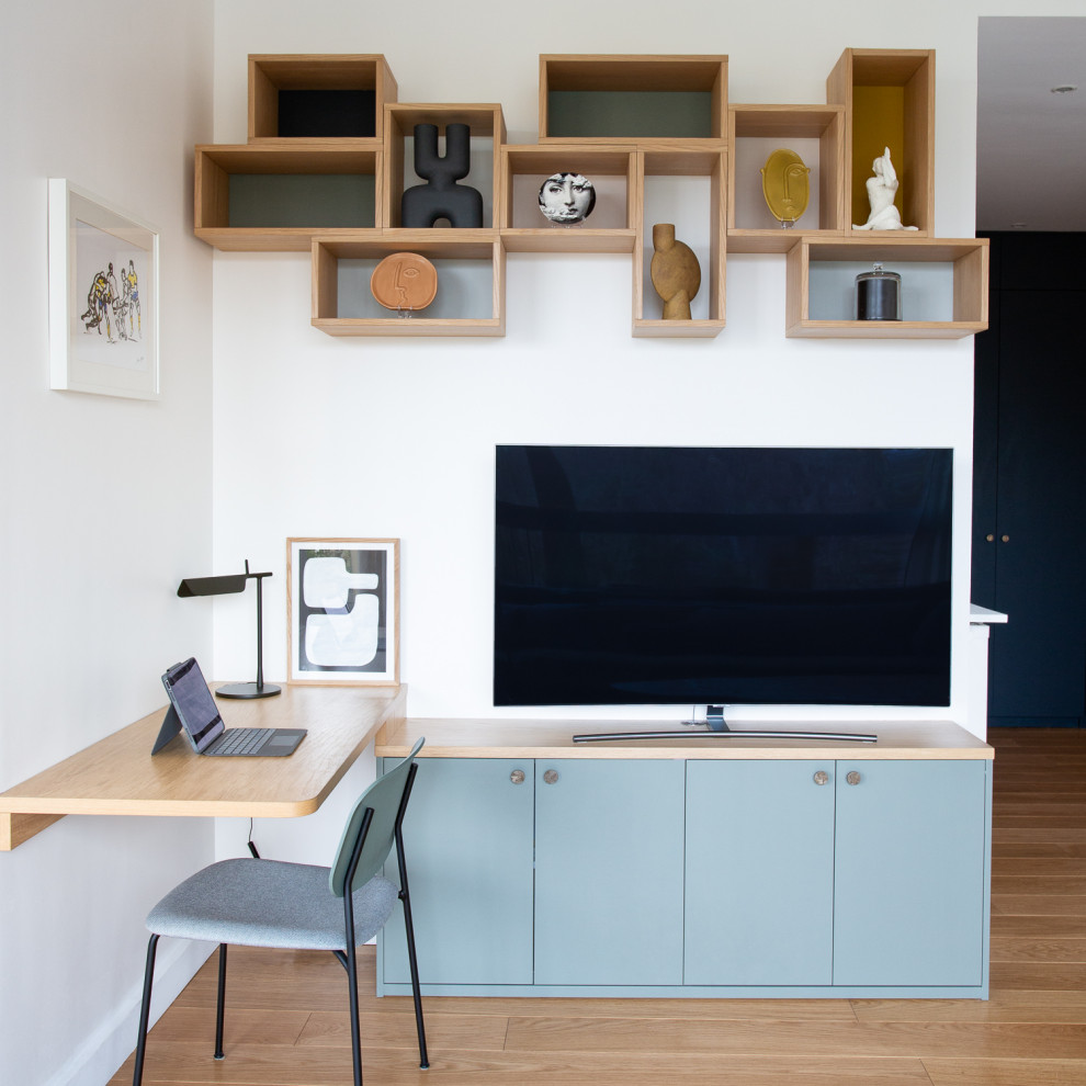 Modelo de despacho actual de tamaño medio con paredes multicolor, suelo de madera clara, escritorio empotrado y madera
