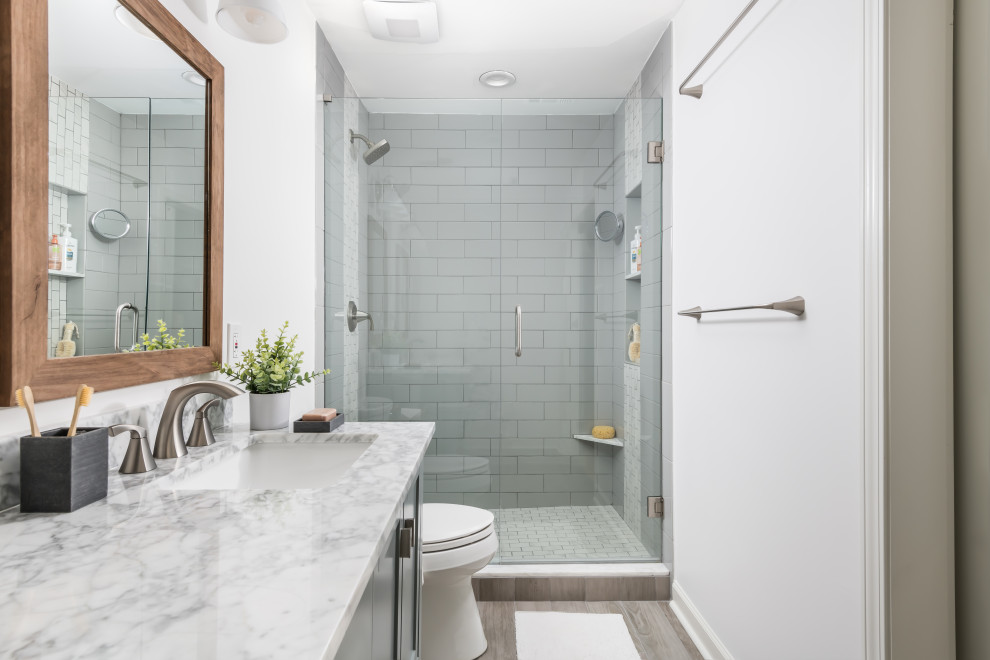 Inspiration för små moderna flerfärgat en-suite badrum, med luckor med infälld panel, gröna skåp, en dusch i en alkov, en toalettstol med separat cisternkåpa, grå kakel, keramikplattor, vita väggar, klinkergolv i porslin, ett undermonterad handfat, marmorbänkskiva och grått golv