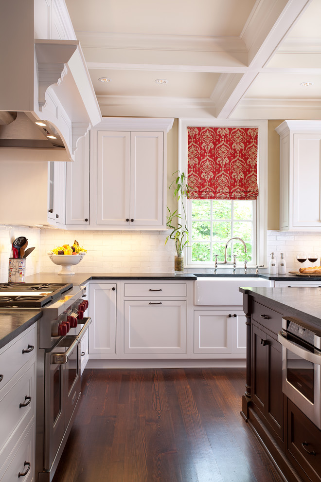 Traditional kitchen in Atlanta with a farmhouse sink, beaded inset cabinets, white cabinets, white splashback, subway tile splashback and stainless steel appliances.