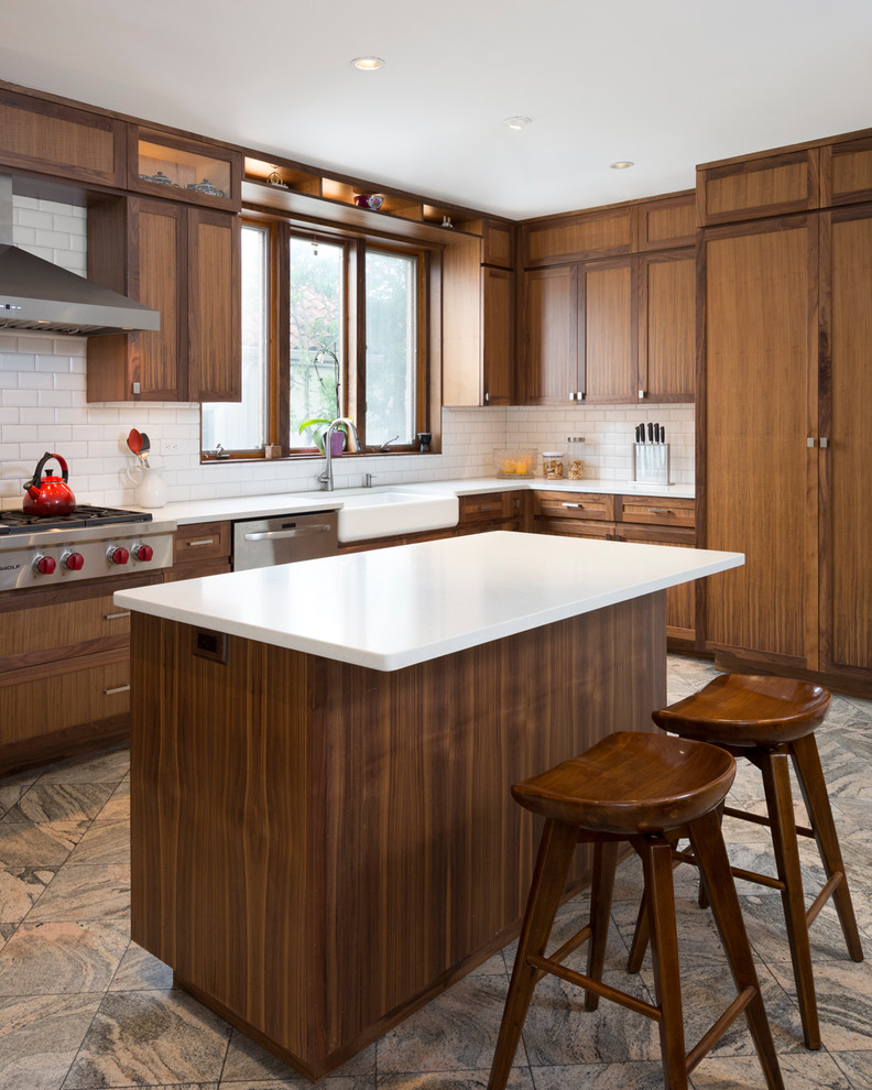 Example of a marble floor eat-in kitchen design in New York with a single-bowl sink, shaker cabinets, medium tone wood cabinets, white backsplash, subway tile backsplash, stainless steel appliances and an island
