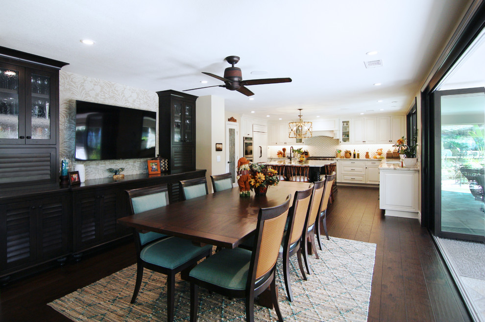 Photo of a mid-sized tropical kitchen/dining combo in Orange County with beige walls, dark hardwood floors and brown floor.