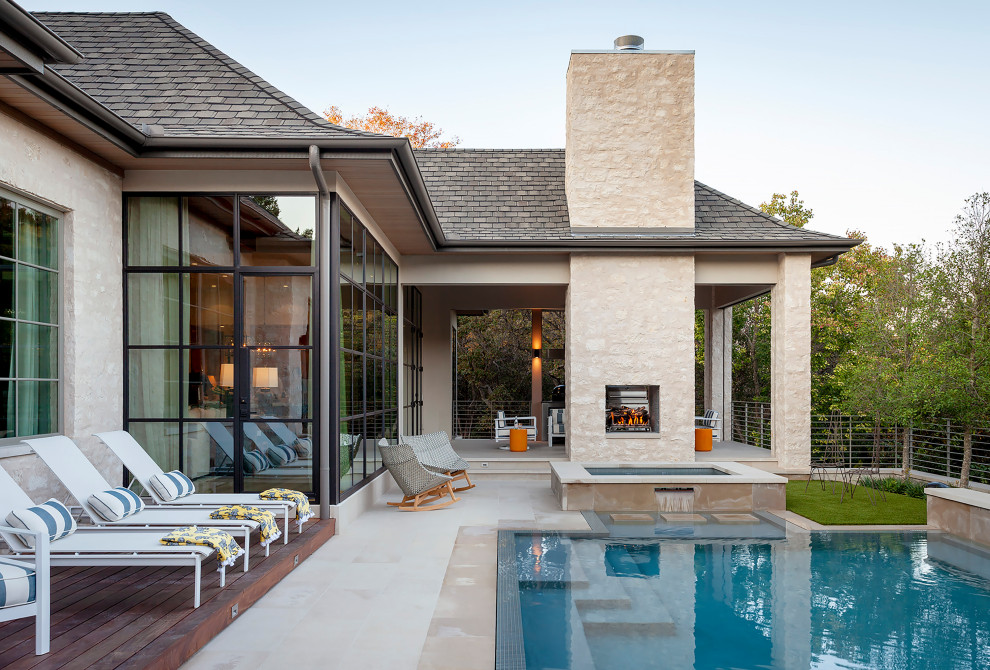 Photo of a large classic back patio in Austin with a fireplace, natural stone paving and no cover.