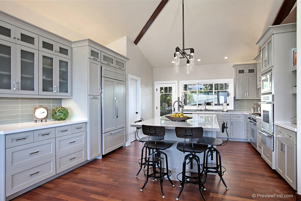 Eat-in kitchen - mid-sized transitional u-shaped medium tone wood floor eat-in kitchen idea in San Diego with shaker cabinets, gray cabinets, gray backsplash, subway tile backsplash, stainless steel appliances, an island and an undermount sink