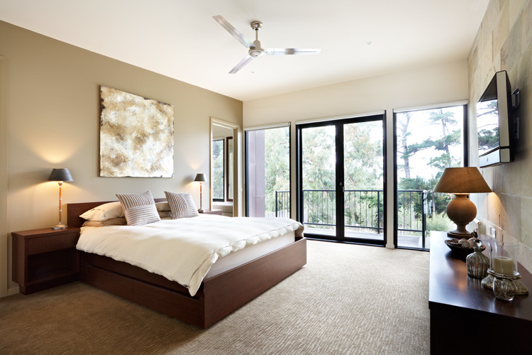 Mid-sized beach style master bedroom in Melbourne with beige walls, carpet and no fireplace.