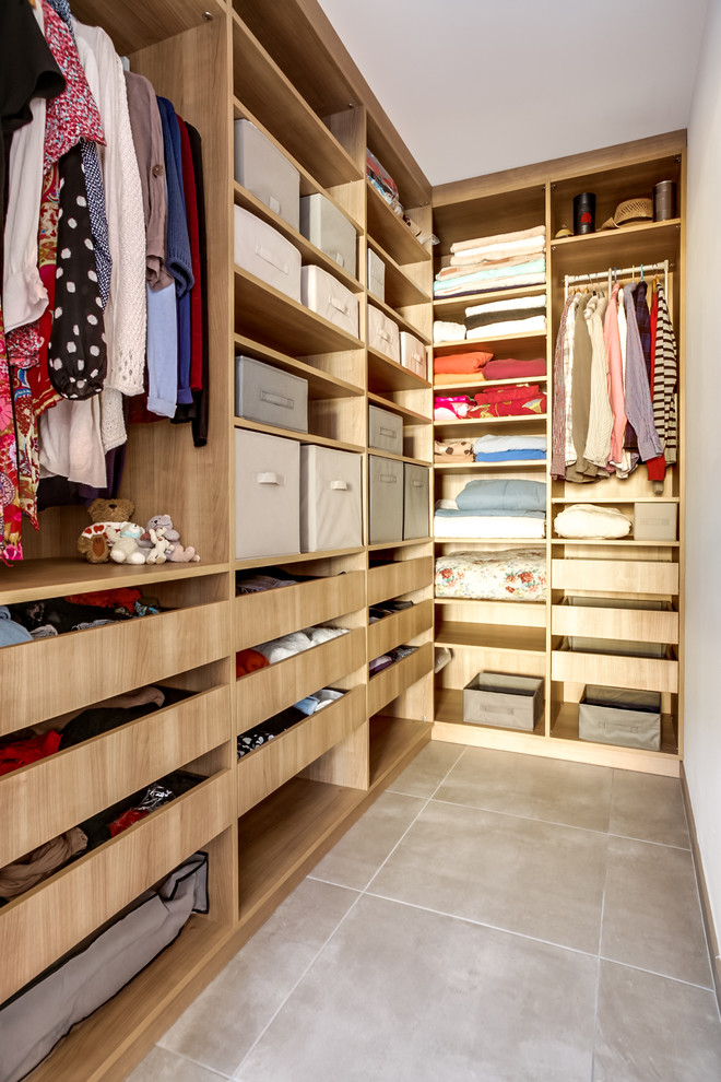 Exemple d'un dressing tendance en bois clair neutre et de taille moyenne avec un placard sans porte et un sol en carrelage de céramique.