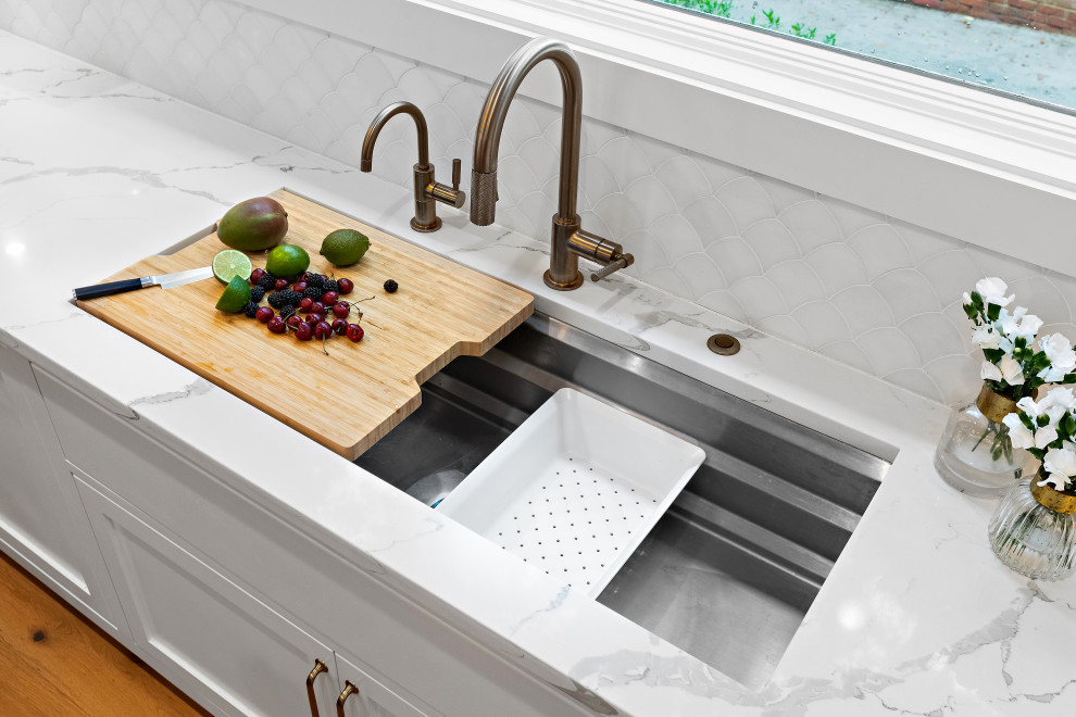Inspiration for a large transitional u-shaped light wood floor kitchen remodel with an undermount sink, shaker cabinets, white cabinets, quartz countertops, white backsplash, marble backsplash, paneled appliances, two islands and white countertops