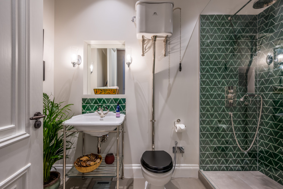 Inspiration for a mid-sized traditional 3/4 bathroom in London with furniture-like cabinets, an open shower, a two-piece toilet, green tile, porcelain tile, grey walls, ceramic floors, a pedestal sink, grey floor and a hinged shower door.