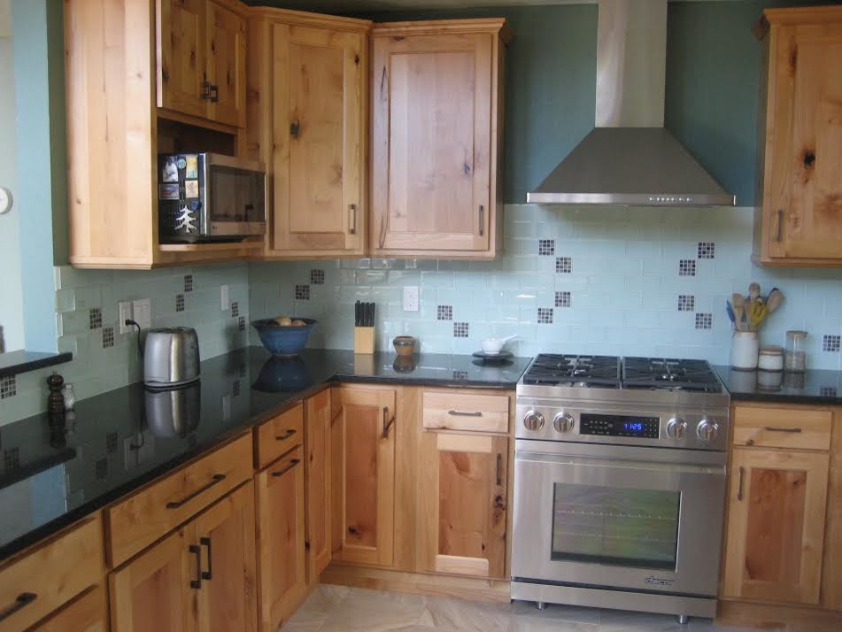 Example of a mid-sized transitional l-shaped ceramic tile and beige floor enclosed kitchen design in Denver with recessed-panel cabinets, light wood cabinets, blue backsplash, stainless steel appliances, an island, an undermount sink, granite countertops and ceramic backsplash