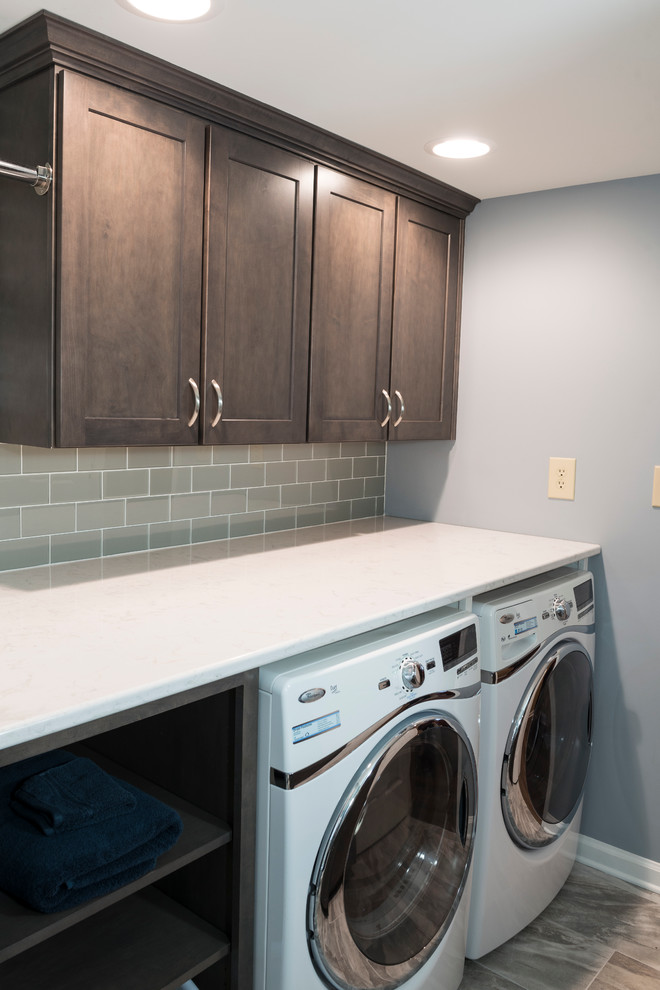Mid-sized traditional galley laundry room in Indianapolis with shaker cabinets, medium wood cabinets, quartz benchtops, blue walls and porcelain floors.