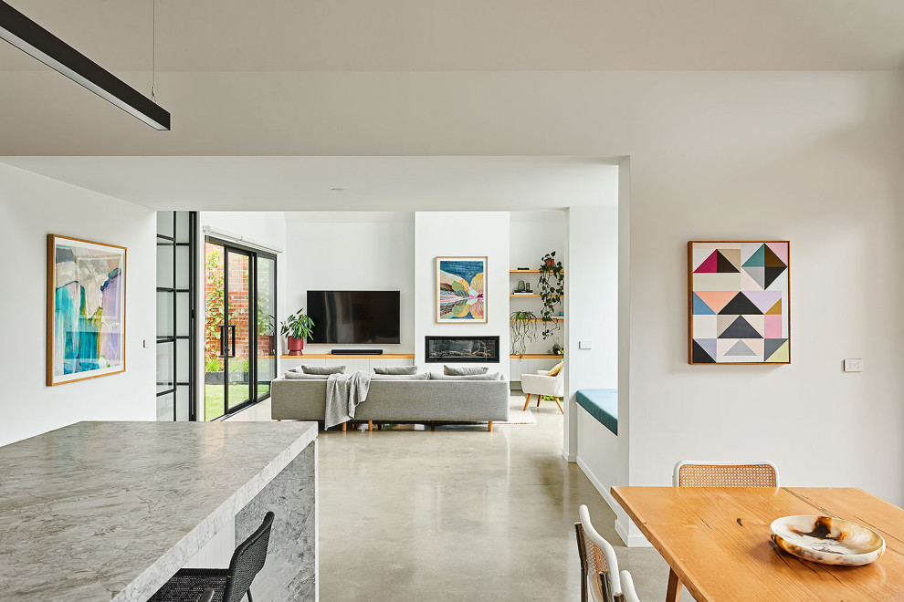 Great room - mid-sized tropical concrete floor, gray floor and vaulted ceiling great room idea in Geelong with white walls, a standard fireplace and a plaster fireplace