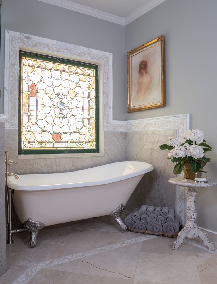 Design ideas for a traditional bathroom in Austin with a claw-foot tub, beige tile, white tile, grey walls and beige floor.