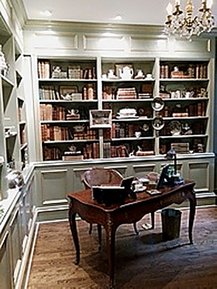 Exempel på ett mellanstort eklektiskt hemmabibliotek, med gröna väggar, mörkt trägolv och ett fristående skrivbord