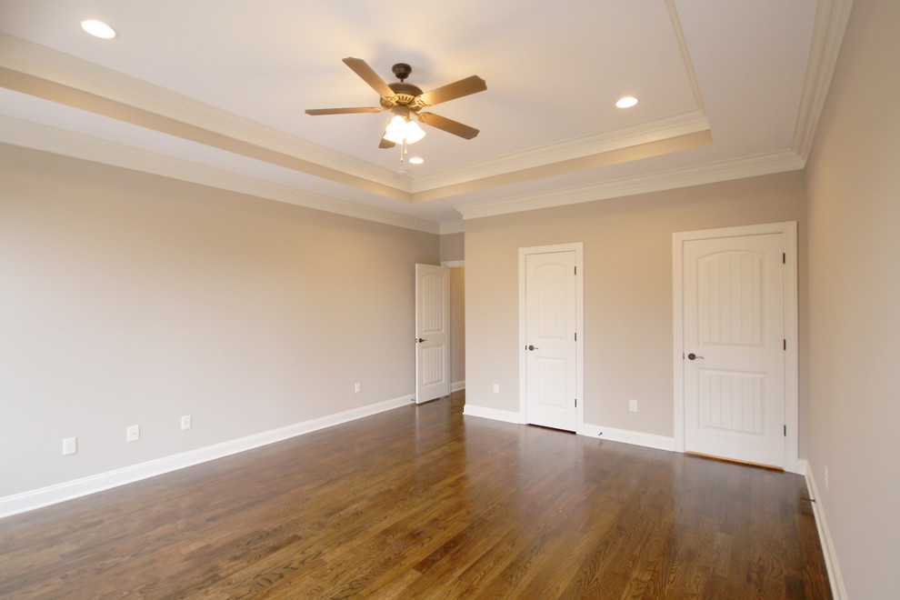 Large arts and crafts master bedroom in Other with beige walls and medium hardwood floors.