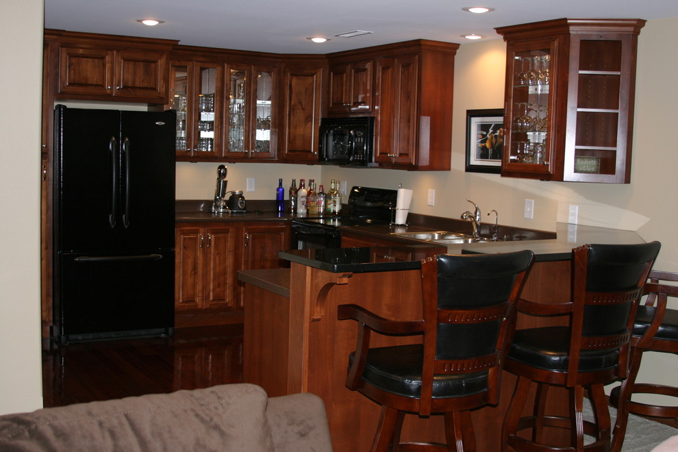 Small u-shaped open concept kitchen photo with raised-panel cabinets, dark wood cabinets, black appliances and a peninsula