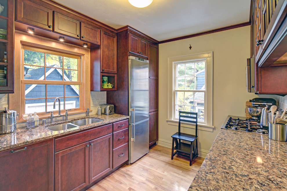 Mid-sized transitional galley medium tone wood floor eat-in kitchen photo with an undermount sink, flat-panel cabinets, medium tone wood cabinets, quartz countertops, white backsplash, subway tile backsplash, stainless steel appliances and an island