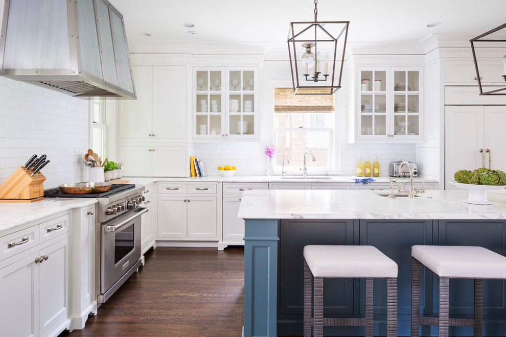 Traditional l-shaped kitchen in Minneapolis with an undermount sink, white cabinets, white splashback, subway tile splashback, stainless steel appliances, dark hardwood floors, with island, marble benchtops and recessed-panel cabinets.