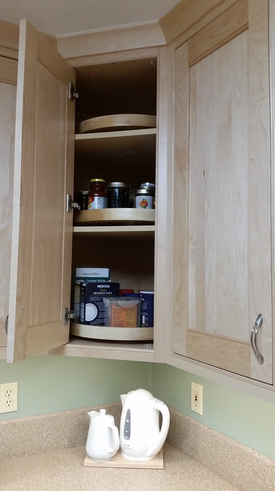 Eat-in kitchen - mid-sized transitional u-shaped laminate floor and beige floor eat-in kitchen idea with a single-bowl sink, beaded inset cabinets, light wood cabinets, solid surface countertops, green backsplash, stainless steel appliances and a peninsula