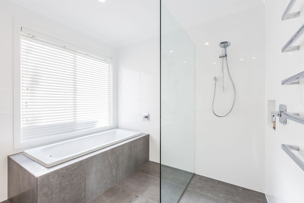 Design ideas for a large contemporary 3/4 bathroom in Adelaide with an open shower, white tile, ceramic tile, white walls, porcelain floors, brown floor, an open shower, flat-panel cabinets, white cabinets, an undermount tub, a one-piece toilet, a vessel sink, marble benchtops and white benchtops.