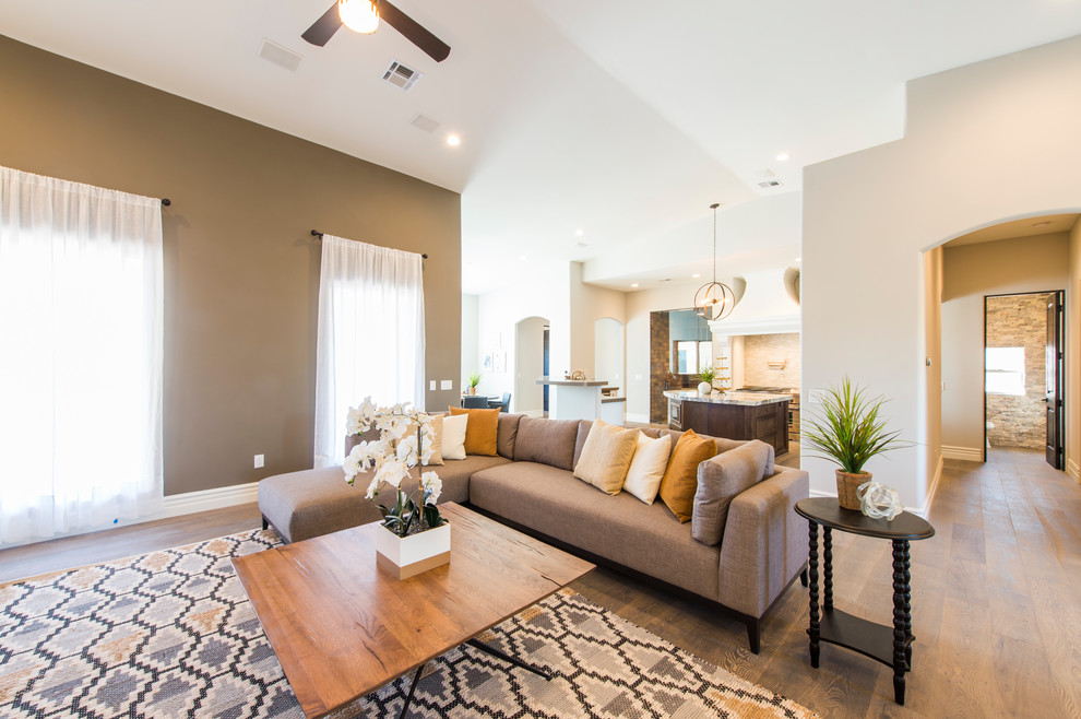 Photo of a mid-sized transitional open concept living room in Phoenix with beige walls, medium hardwood floors and brown floor.