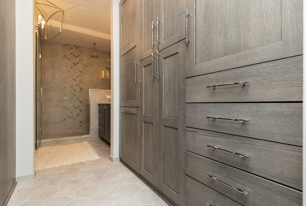 This is an example of a medium sized traditional walk-in wardrobe in Other with flat-panel cabinets, grey cabinets, porcelain flooring and grey floors.