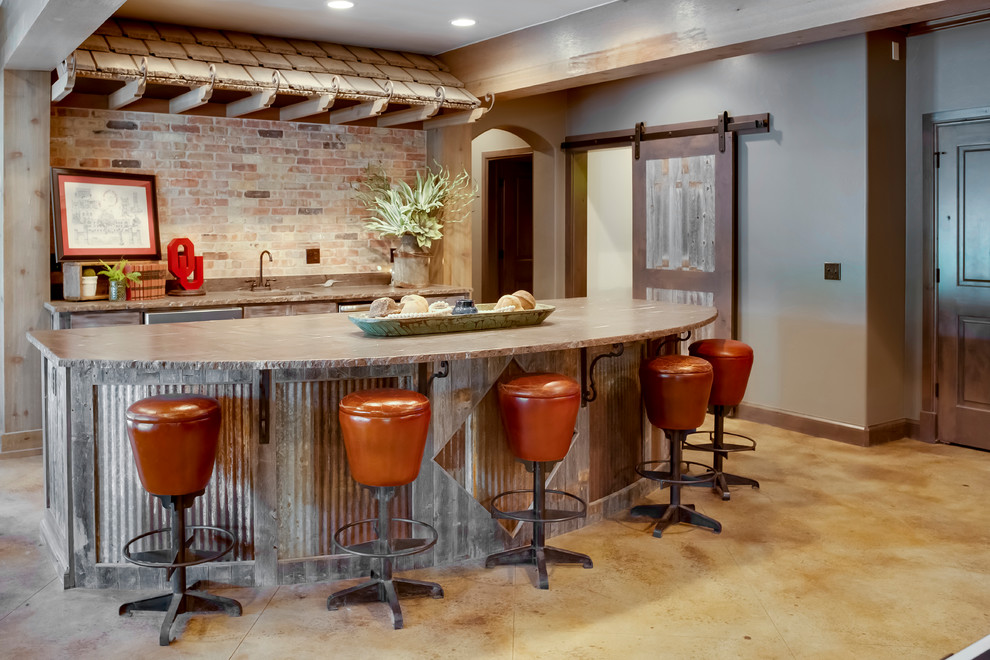 Photo of a country seated home bar in Oklahoma City with concrete benchtops, brick splashback, concrete floors and beige floor.
