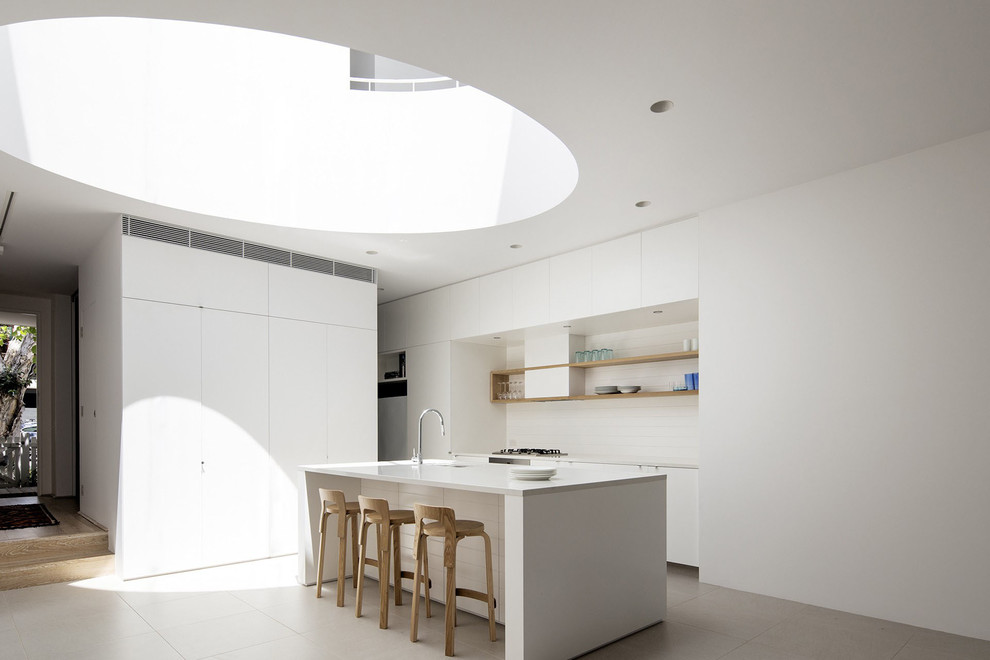 This is an example of a mid-sized contemporary galley kitchen in Sydney with flat-panel cabinets and with island.