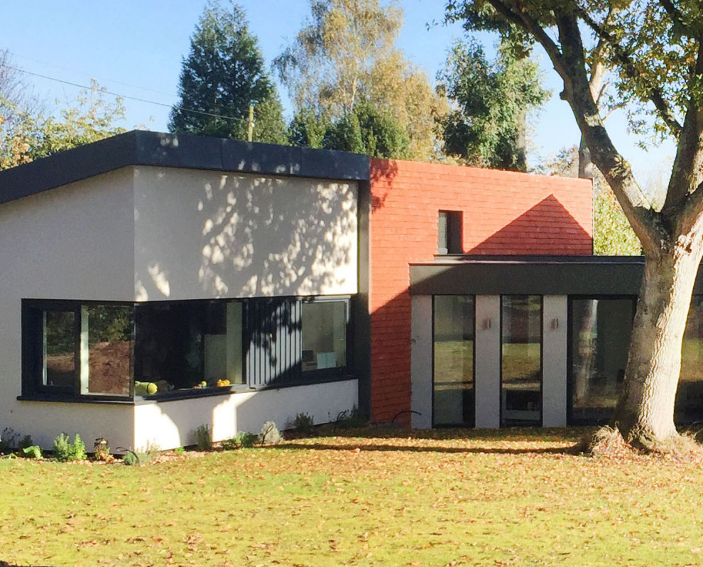 Photo of a large contemporary two floor detached house in Kent with wood cladding.