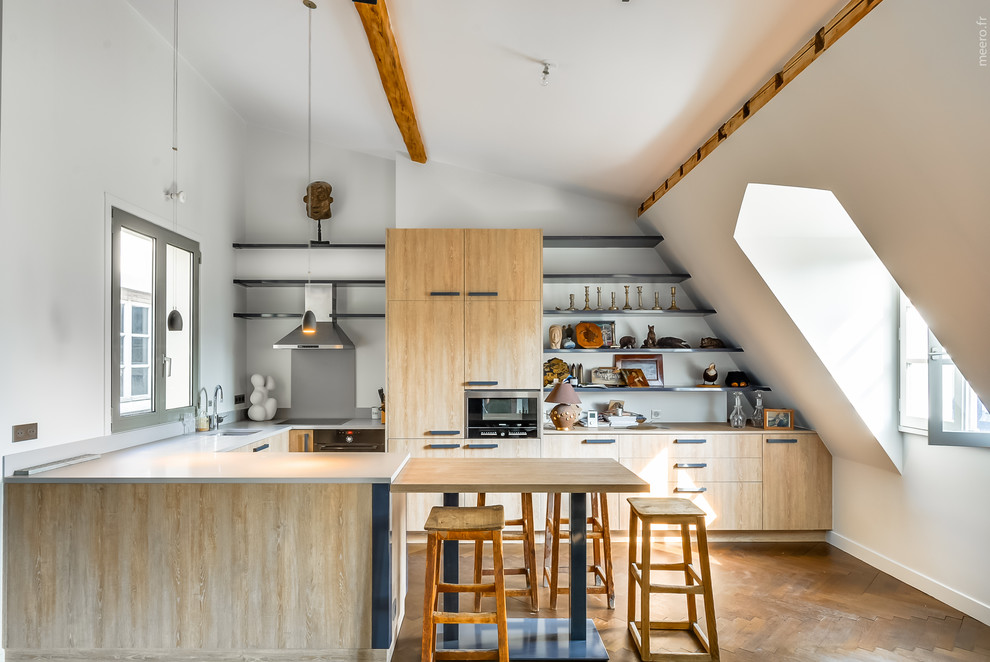 Inspiration for a large eclectic u-shaped eat-in kitchen in Paris with flat-panel cabinets, light wood cabinets, medium hardwood floors and a peninsula.