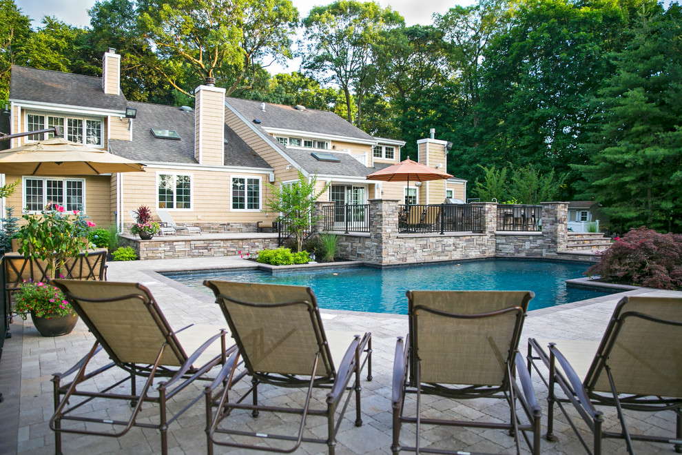 Large traditional backyard custom-shaped pool in New York with concrete pavers.