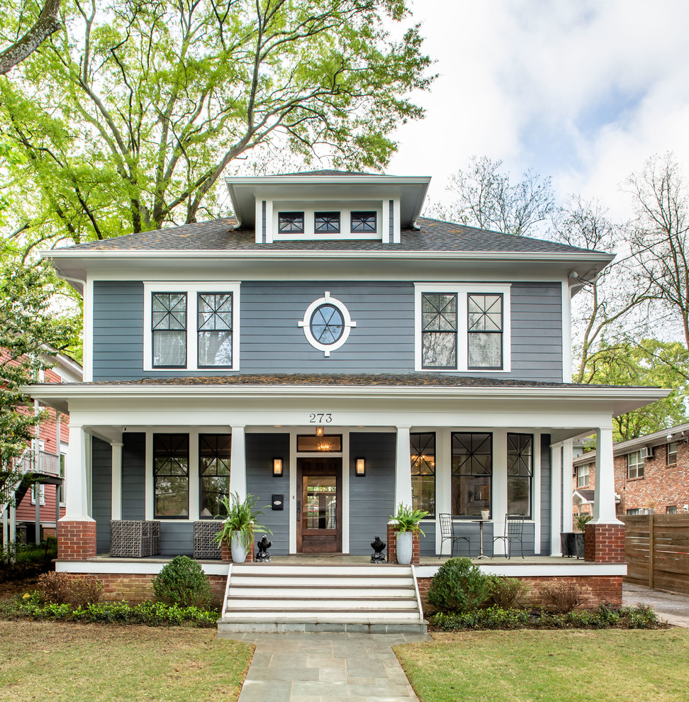 This is an example of a traditional two-storey grey house exterior in Atlanta with a hip roof and a shingle roof.