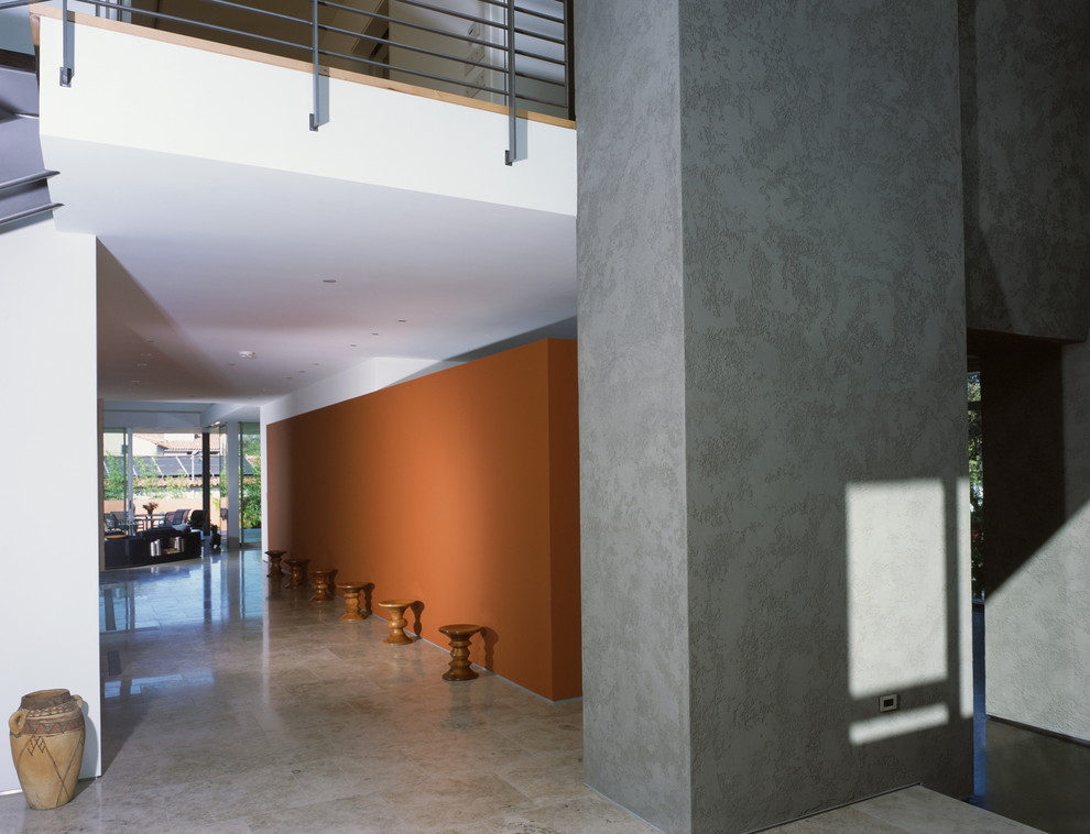 Inspiration for a modern hallway in Los Angeles with orange walls and grey floor.