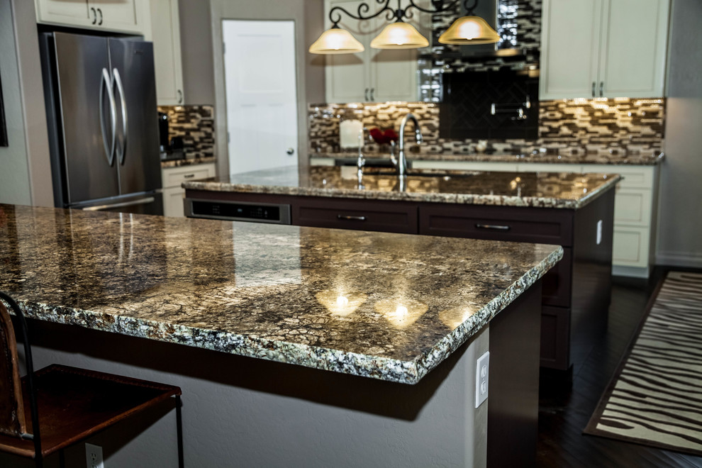 Eat-in kitchen - large transitional l-shaped dark wood floor eat-in kitchen idea in Phoenix with an undermount sink, recessed-panel cabinets, white cabinets, granite countertops, multicolored backsplash, glass tile backsplash, stainless steel appliances and an island