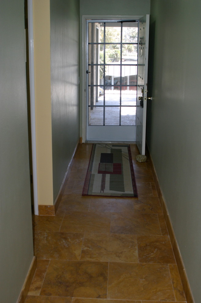 Photo of a small traditional hallway in Los Angeles with green walls and travertine floors.
