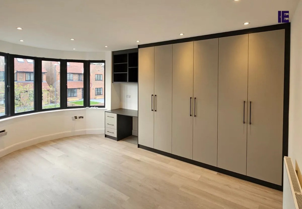 Inspiration for a large modern built-in wardrobe in London with flat-panel cabinets, grey cabinets and feature lighting.