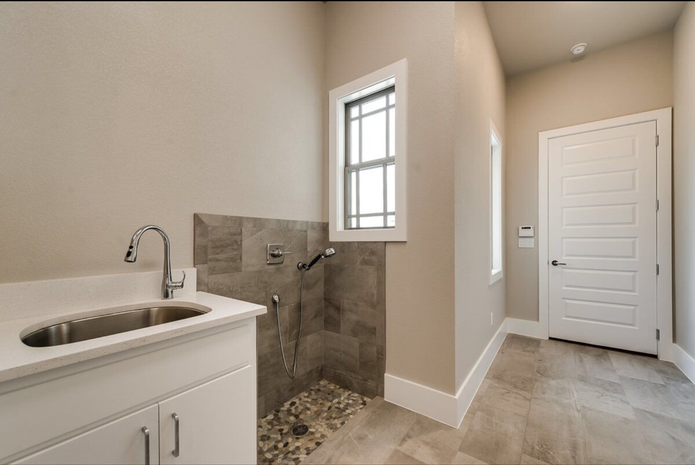 Inspiration for a large contemporary single-wall utility room in Dallas with an undermount sink, flat-panel cabinets, white cabinets, quartzite benchtops, beige walls, ceramic floors and a side-by-side washer and dryer.