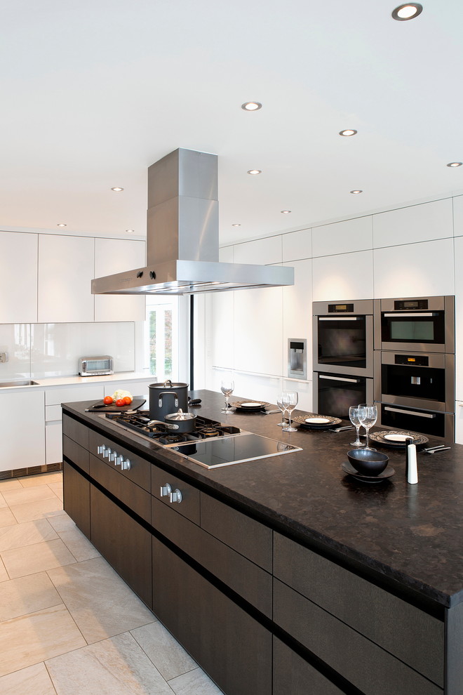 This is an example of a large contemporary l-shaped eat-in kitchen in New York with a single-bowl sink, flat-panel cabinets, white cabinets, marble benchtops, white splashback, glass sheet splashback, stainless steel appliances, ceramic floors and with island.