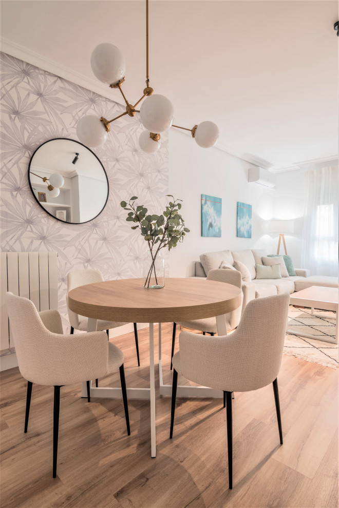 Свежая идея для дизайна: маленькая гостиная-столовая в скандинавском стиле с белыми стенами, полом из ламината, коричневым полом и обоями на стенах для на участке и в саду - отличное фото интерьера