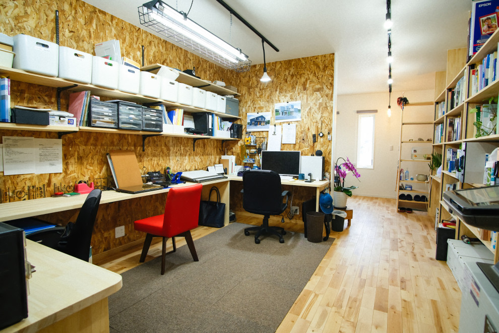 Idéer för mellanstora industriella hobbyrum, med bruna väggar, ljust trägolv, ett inbyggt skrivbord och beiget golv