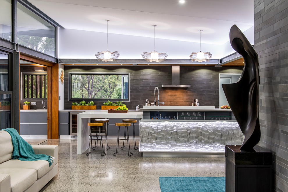 Expansive contemporary galley kitchen pantry in Brisbane with a double-bowl sink, flat-panel cabinets, grey cabinets, stainless steel benchtops, grey splashback, ceramic splashback, stainless steel appliances, concrete floors and multiple islands.