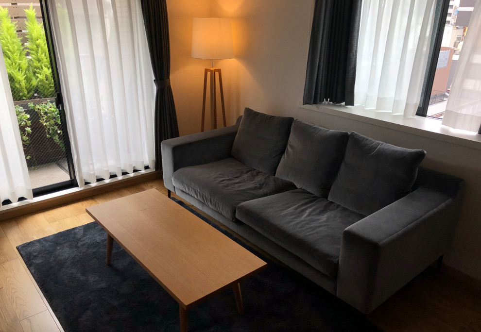 На фото: открытая гостиная комната в белых тонах с отделкой деревом в скандинавском стиле с белыми стенами, полом из фанеры, телевизором на стене, потолком с обоями и обоями на стенах без камина с