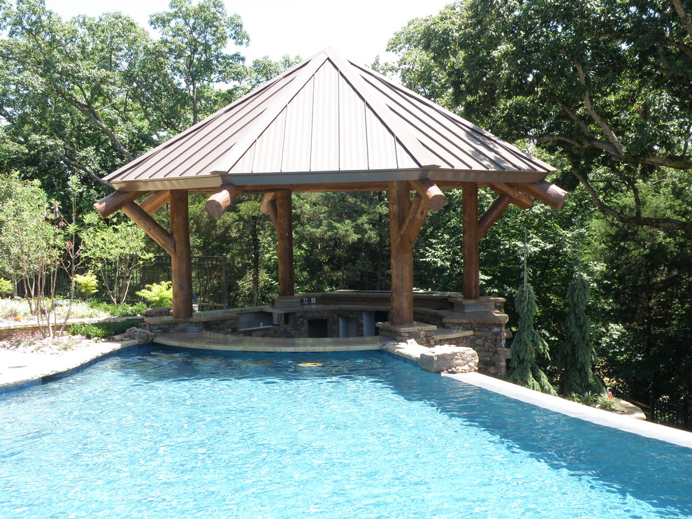 Photo of a large arts and crafts backyard custom-shaped pool in Kansas City with a water feature.