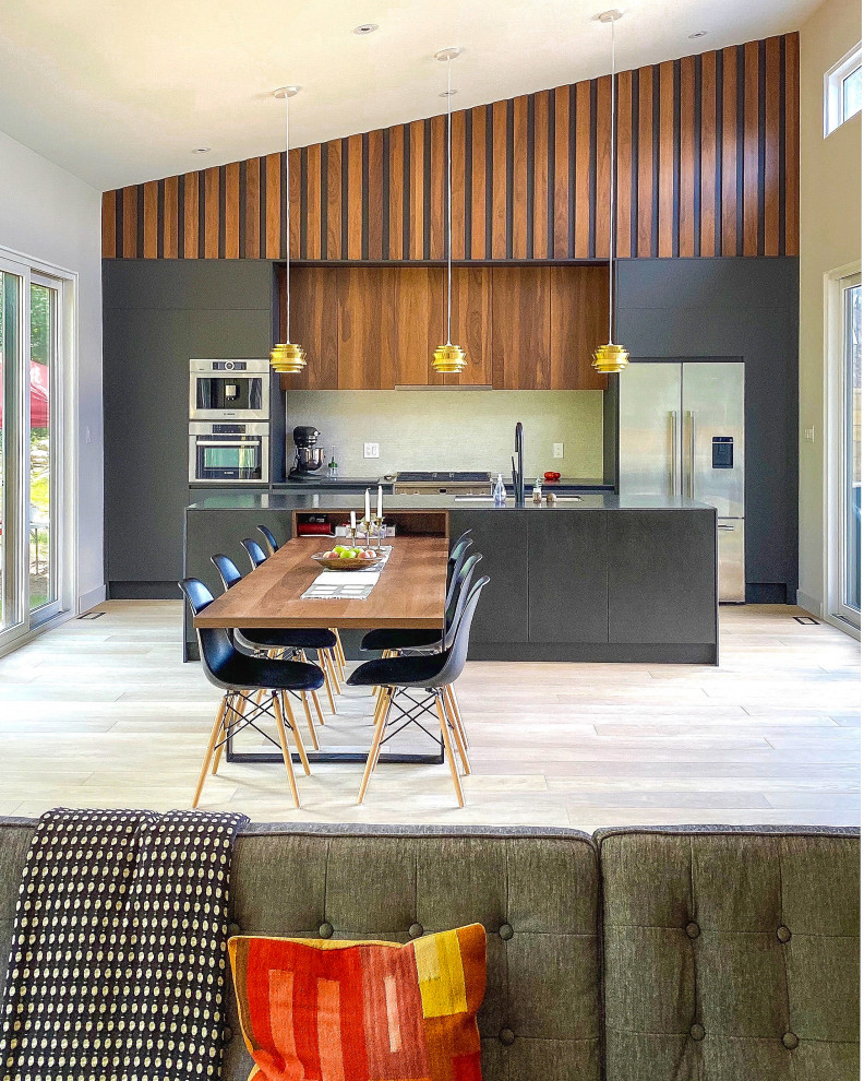 Mid-sized modern eat-in kitchen in Toronto with flat-panel cabinets, dark wood cabinets, tile benchtops, beige splashback, light hardwood floors, with island and black benchtop.