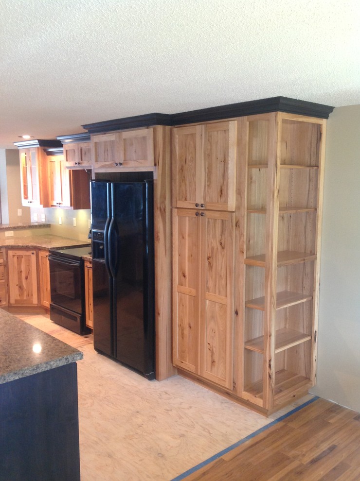 Inspiration for a mid-sized l-shaped open concept kitchen remodel with raised-panel cabinets, light wood cabinets, laminate countertops, black appliances and a peninsula