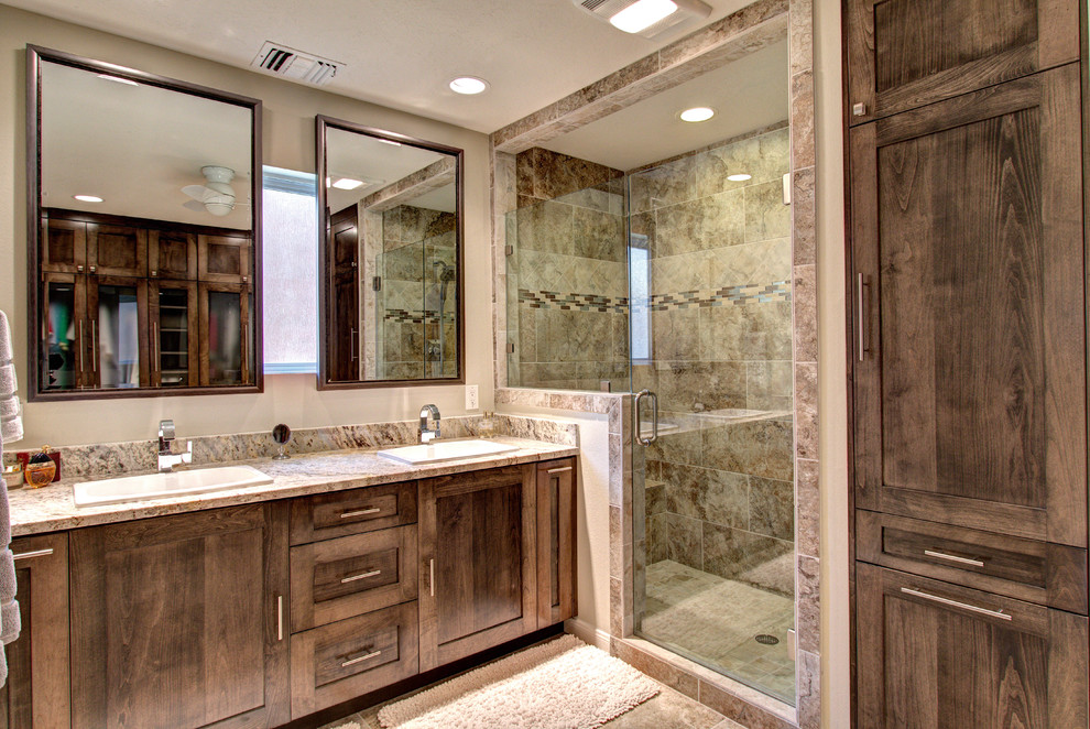This is an example of a mid-sized contemporary master bathroom in Houston with flat-panel cabinets, medium wood cabinets, a corner shower, a two-piece toilet, multi-coloured tile, porcelain tile, beige walls, porcelain floors, a drop-in sink and granite benchtops.