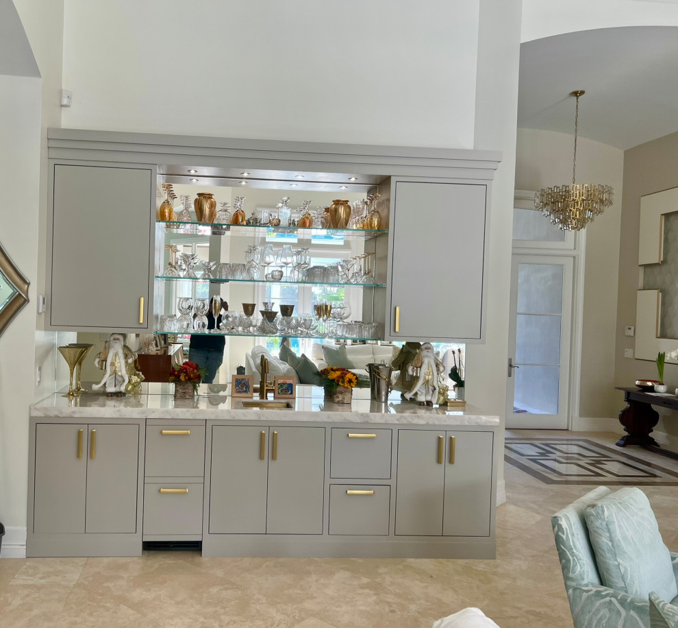 Photo of a transitional single-wall home bar in Miami with an undermount sink, beaded inset cabinets, grey cabinets, quartzite benchtops, mirror splashback and white benchtop.